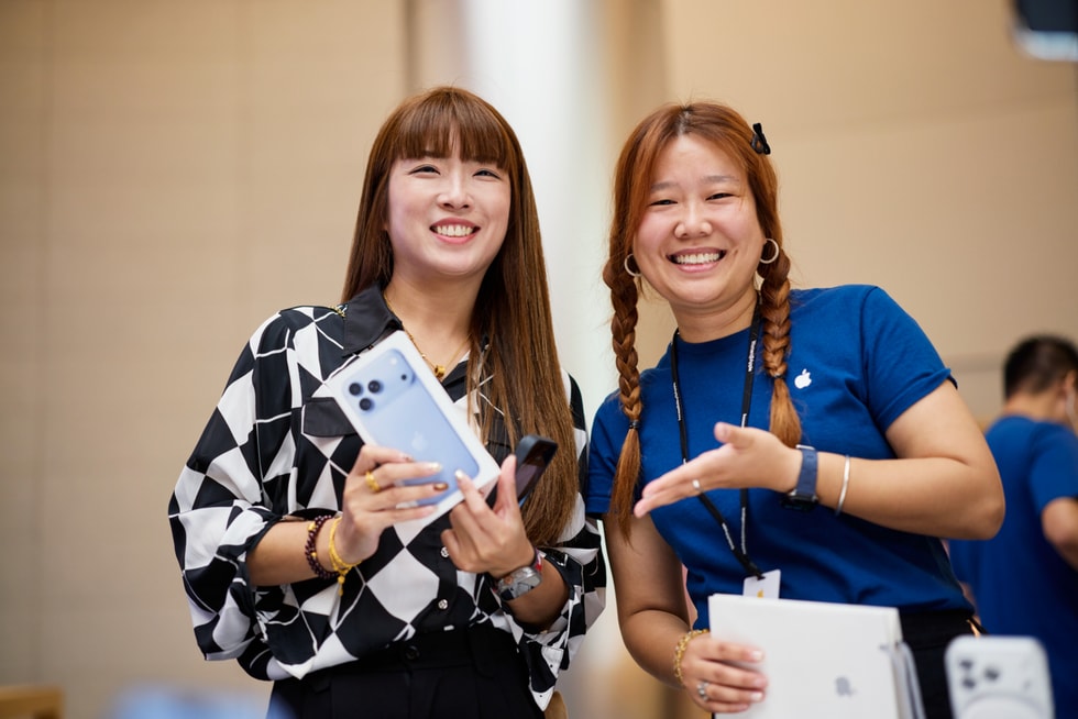 A customer shows off their iPhone 18 Pro purchase next to a smiling team member at Apple Jing’an.